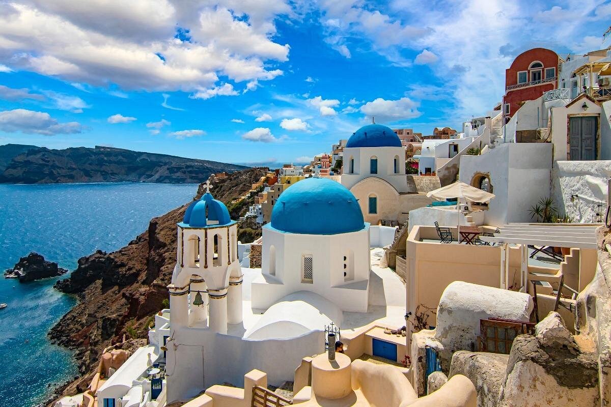 White houses and blue-domed churches on the cliffs of Oia above the Aegean Sea