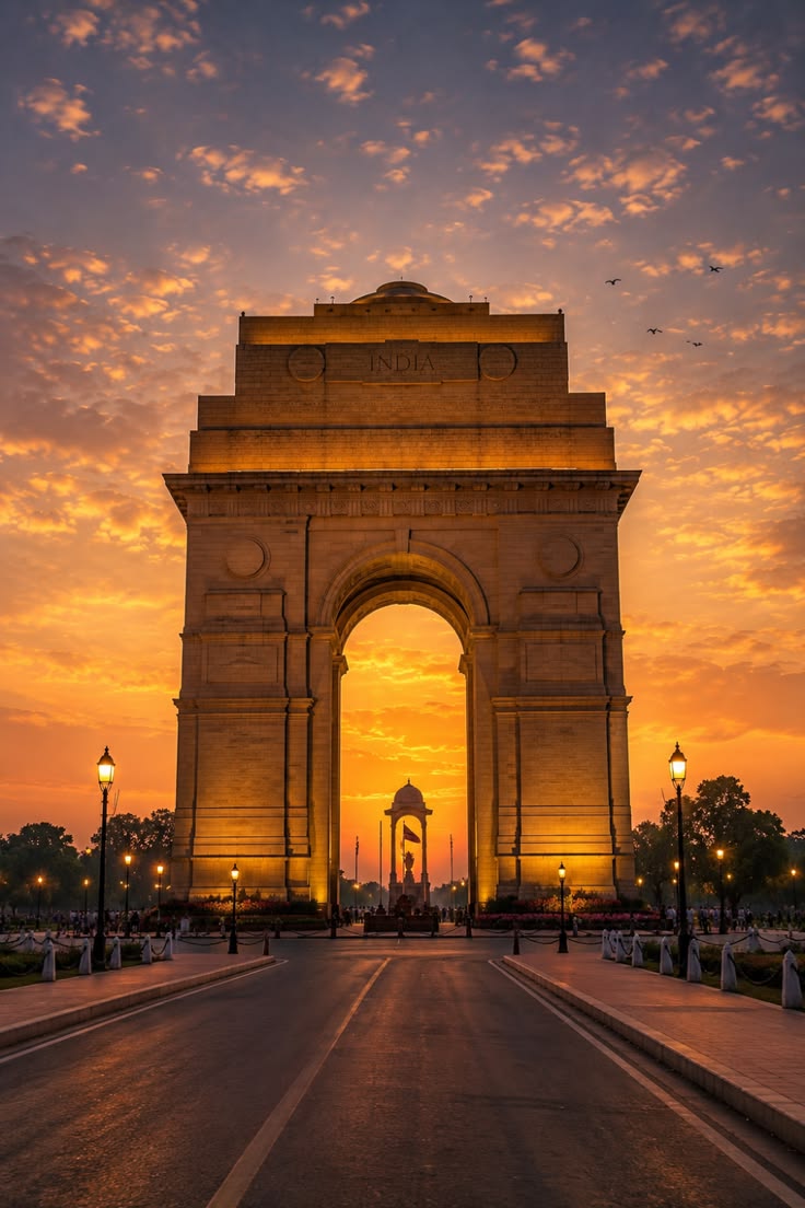 India Gate in New Delhi glowing at sunset under a dramatic sky