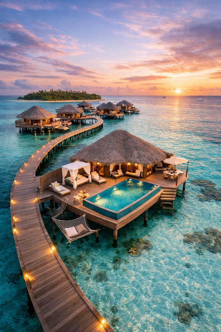 Overwater villas with a private pool on a turquoise lagoon at sunset