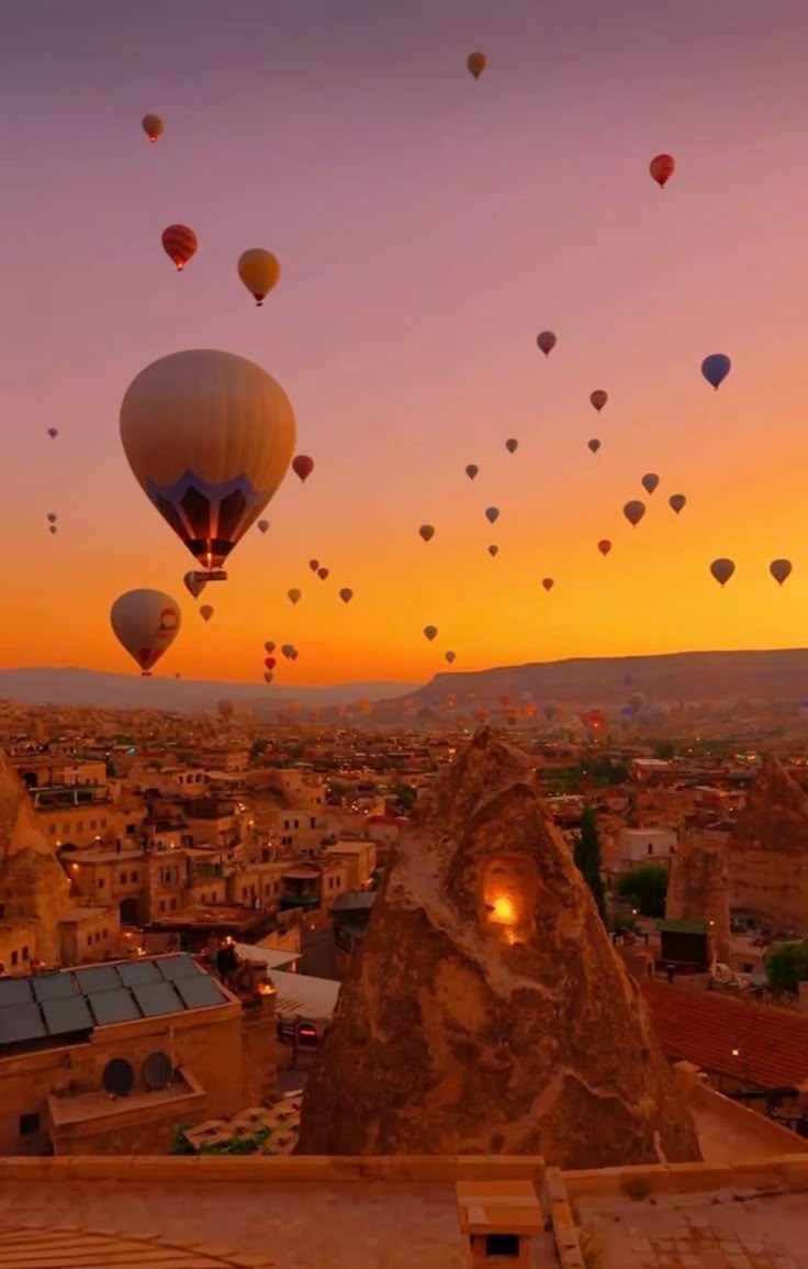 Hot-air balloons drifting over the rock formations of Cappadocia at sunrise